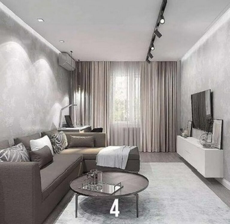 Nowoczesny salon z szarymi ścianami i eleganckim oświetleniem, idealny do aranżacji wnętrz. Firma remontowa zrealizowała stylowe wykończenia, łącząc komfort z funkcjonalnością. Przestrzeń z sofą, stolikiem kawowym i telewizorem, nadająca się do inspiration dla przyszłych remontów.