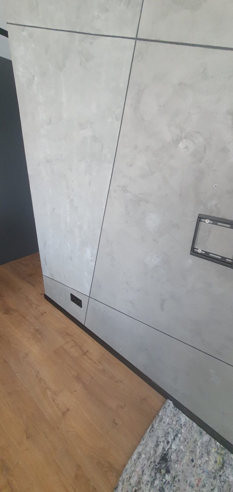 Nowoczesne wykończenie wnętrz z szarymi ścianami i drewnianą podłogą, idealne przykład dla firm remontowych. Remont w eleganckim stylu, podkreślający estetykę nowoczesnych przestrzeni.