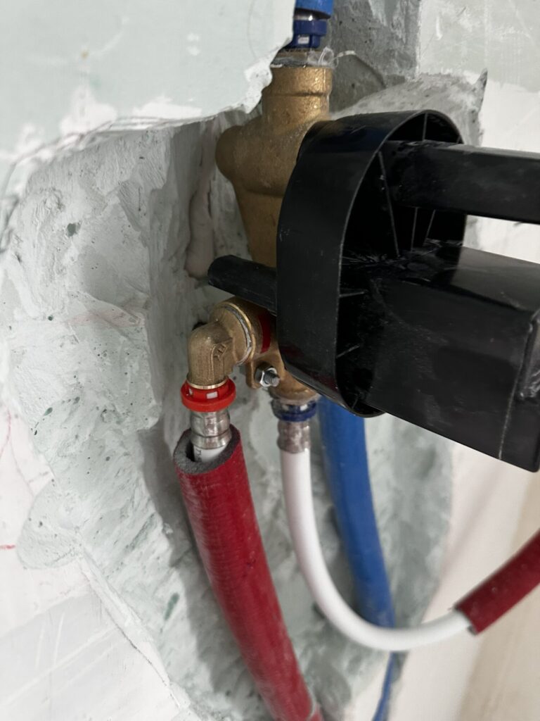 Instalacja hydrauliczna podczas remontu, pokazująca elementy systemu wodnego i wykończenia wnętrz, w wykonaniu profesjonalnej firmy remontowej.