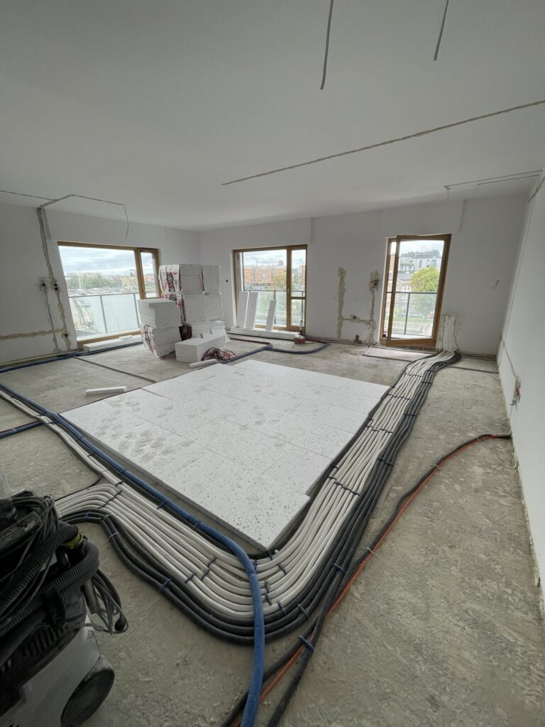 Nowoczesne wnętrze w trakcie remontu, z widokiem na instalacje elektryczne i budowlane, idealne dla firmy remontowej specjalizującej się w wykończeniach wnętrz.