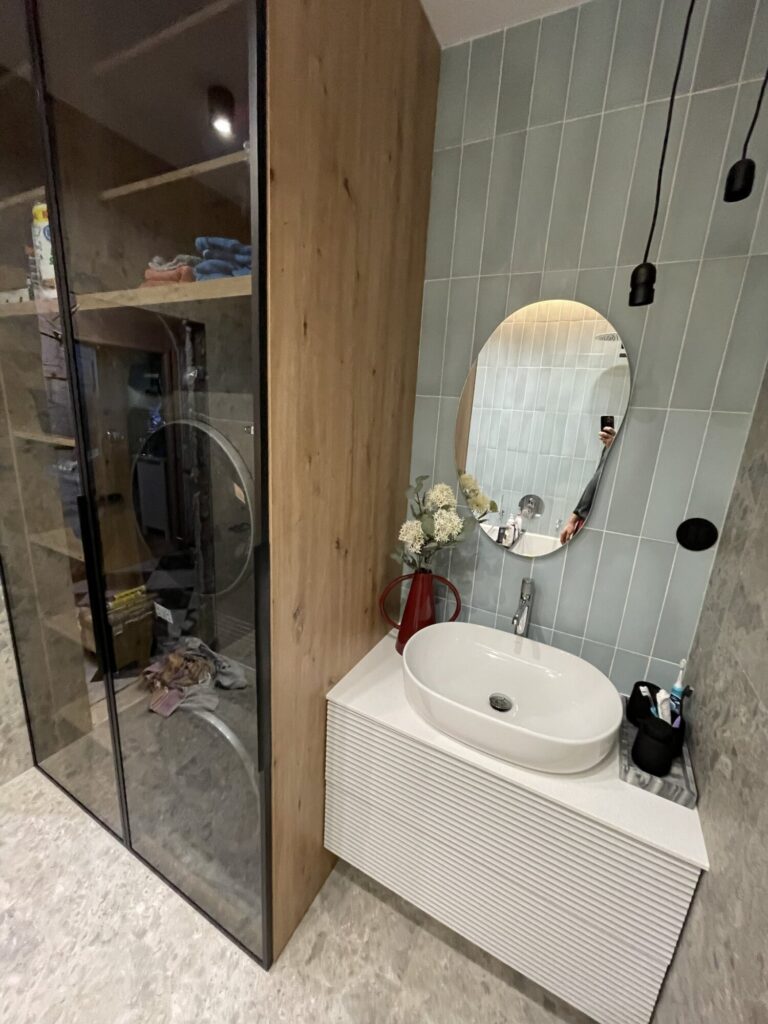 Nowoczesna łazienka z eleganckimi wykończeniami wnętrz, z ceramicznymi kafelkami oraz drewnianymi akcentami. Wykonana przez profesjonalną firmę remontową, idealna do inspiracji na remont.