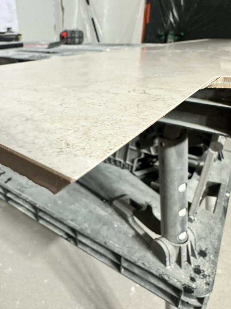 Płytki ceramiczne na stole roboczym podczas remontu wnętrza, przygotowane do wykończeń przez firmę remontową.