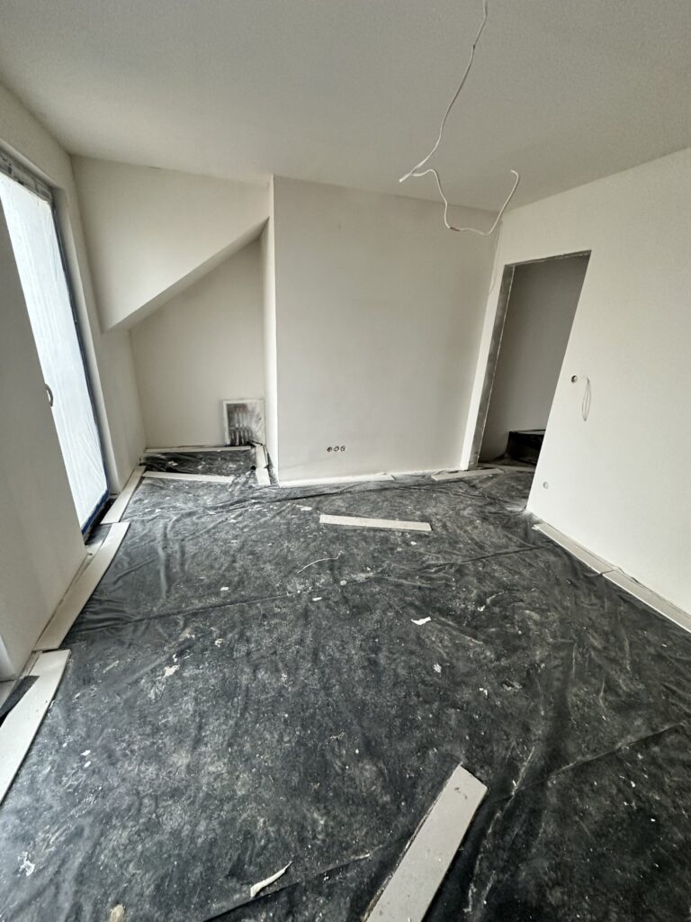 Nowoczesne wnętrze w trakcie remontu z odsłoniętymi podłogami i ścianami przed wykończeniami. Przestrzeń gotowa na prace firmy remontowej. - Kartuzy