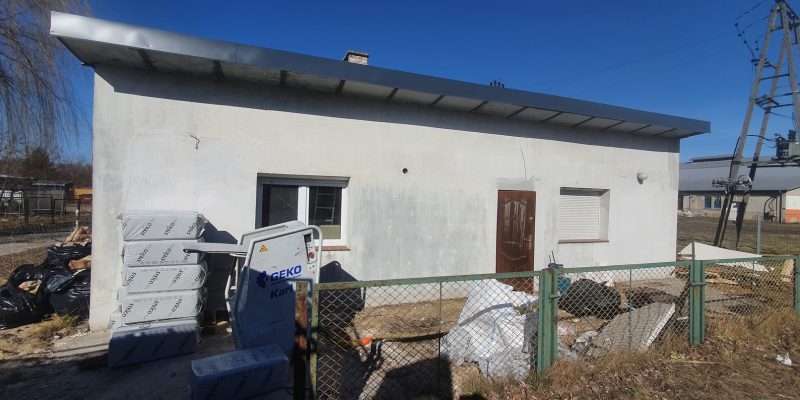 Remont budynku mieszkalnego z przygotowaniami do wykończeń wnętrz, z widocznym sprzętem budowlanym i odpadami po remoncie, w ofercie firmy remontowej.